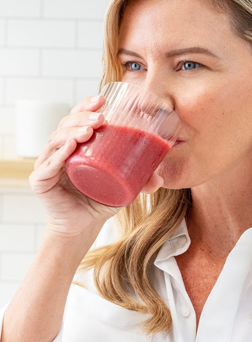 A woman stirring a drink of MONAT COLLAGEN KEY with a spoon