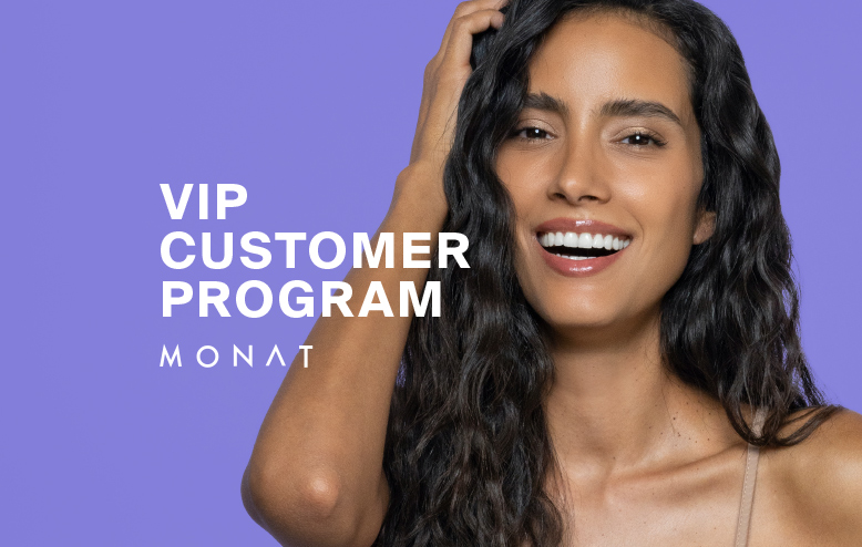 The MONAT VIP Points logo overlaying a photo of a brunette female with wavy hair that is smiling.