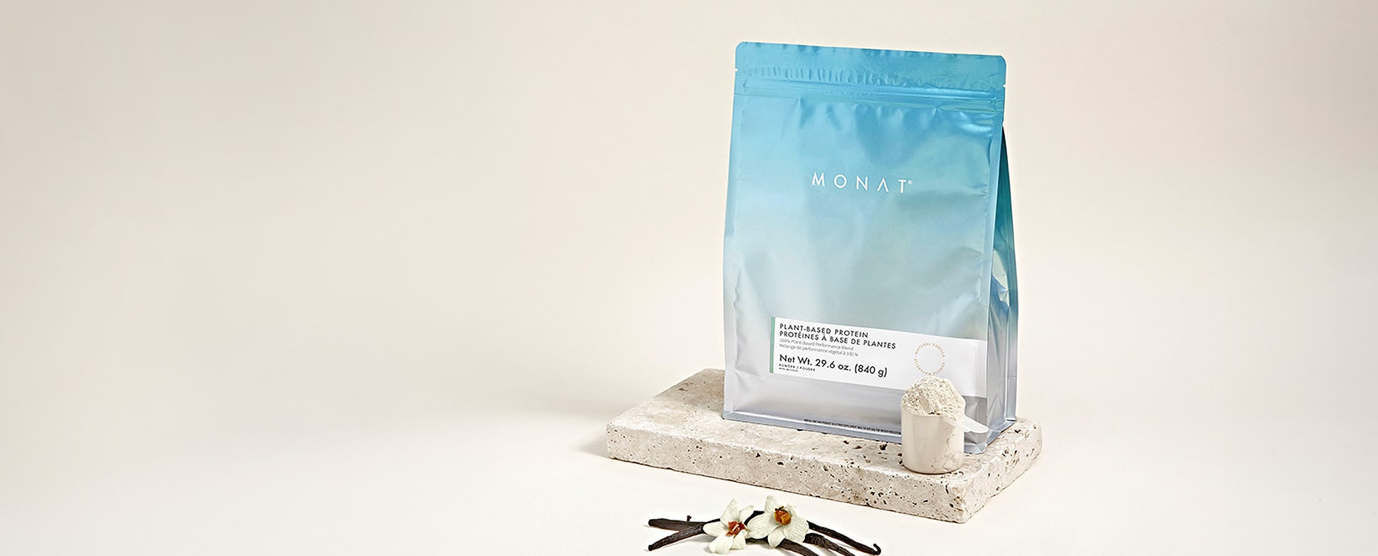 Les Protéines à base de plantes MONAT sur une plaque de marbre, à côté d’une portion préparée des Protéines à base de plantes