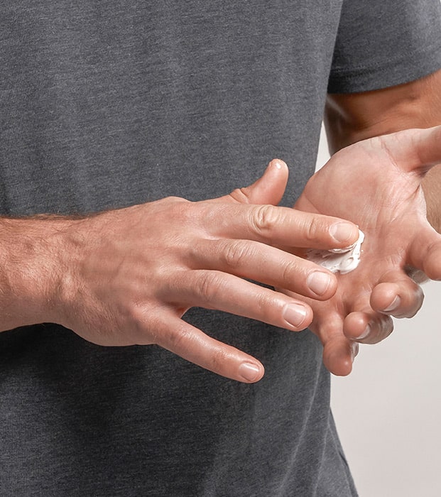 picture of a man working a small amount of product into his hands.