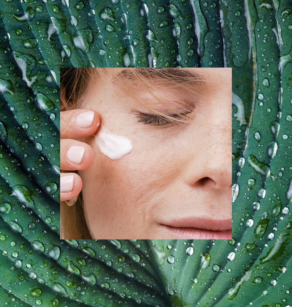 A macro shot of skincare cream applied under the eye near overlaying a leaf.