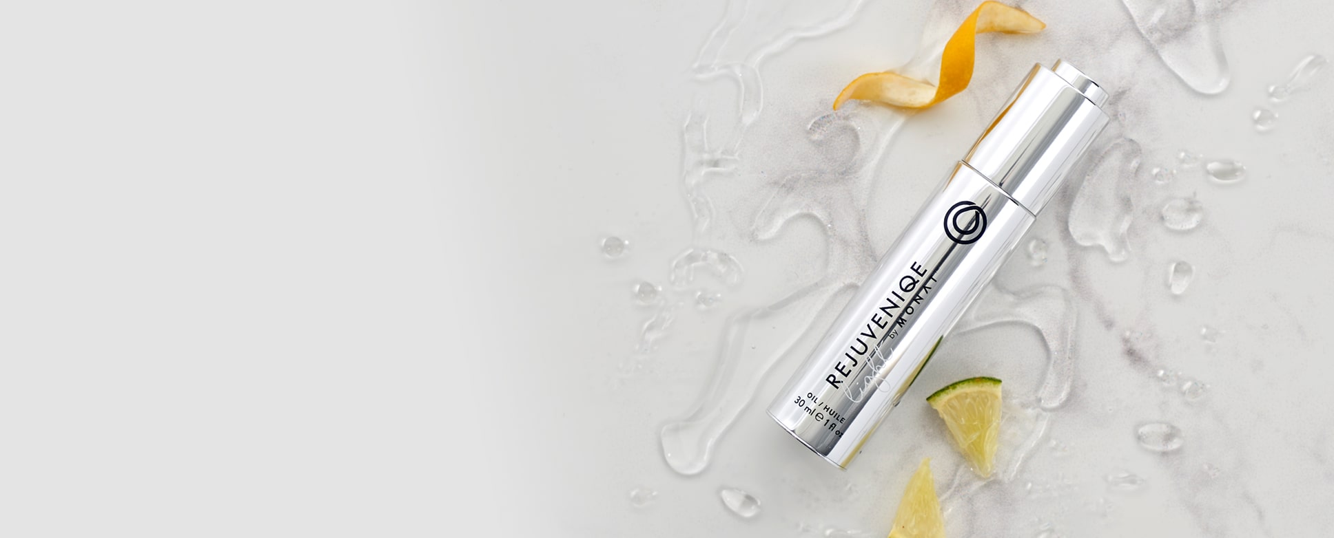 REJUVENIQE® laying on a flat surface, along with ingredients such as lemon and lime slices 