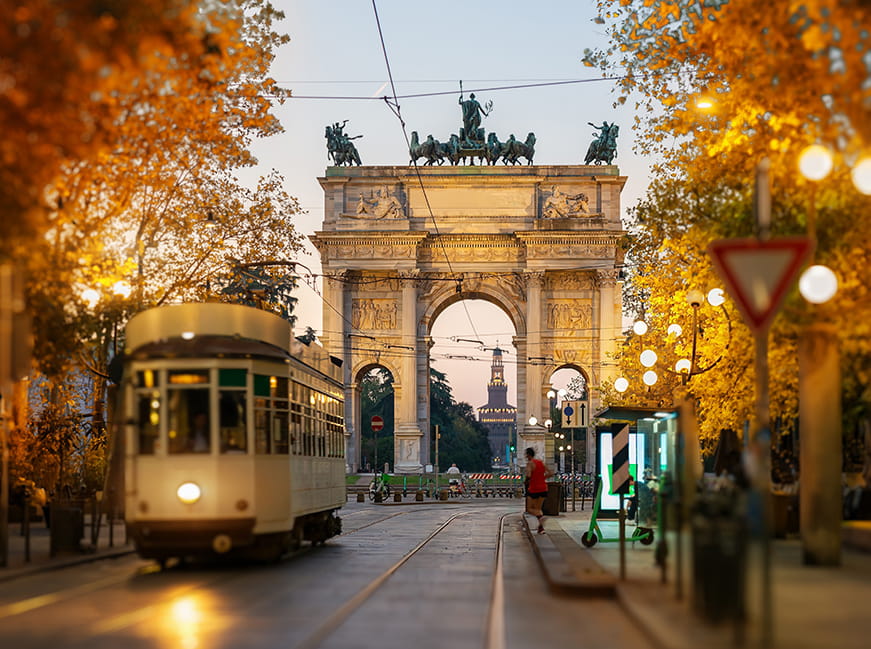 street scene with a tram near a historic arch