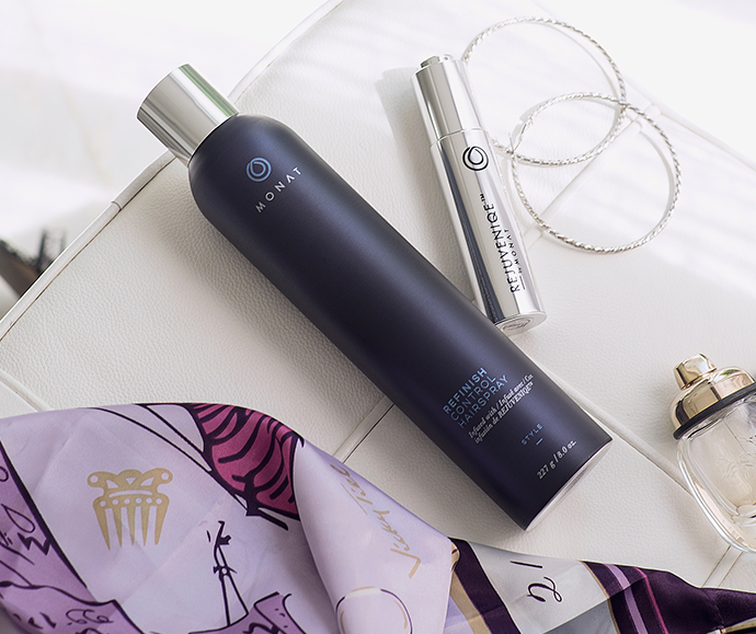 MONAT’s Refinish Control Hairspray and MONAT’S Rejuvinique products laying flat on top of leather clutch as essential products that will help you learn how to french braid your hair in 3 minutes or less.