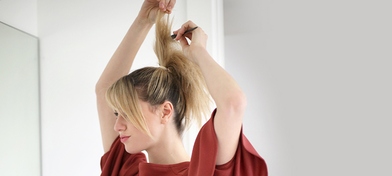 woman-with-rat-tail-comb,-putting-her-hair-in-updo