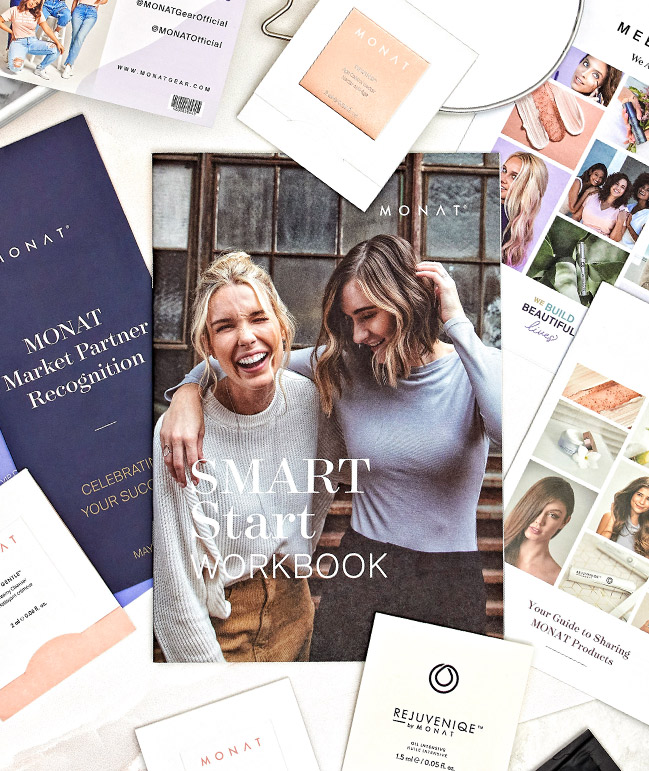 Picture of two women sitting on a couch holding and reading multiple MONAT publications.