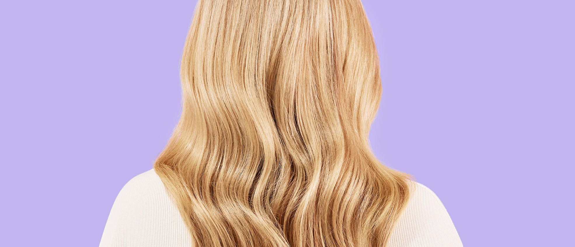 Backhead of a blonde woman showcasing her results after applying the treatment on her hair. Subject poses in front of a lavender background.