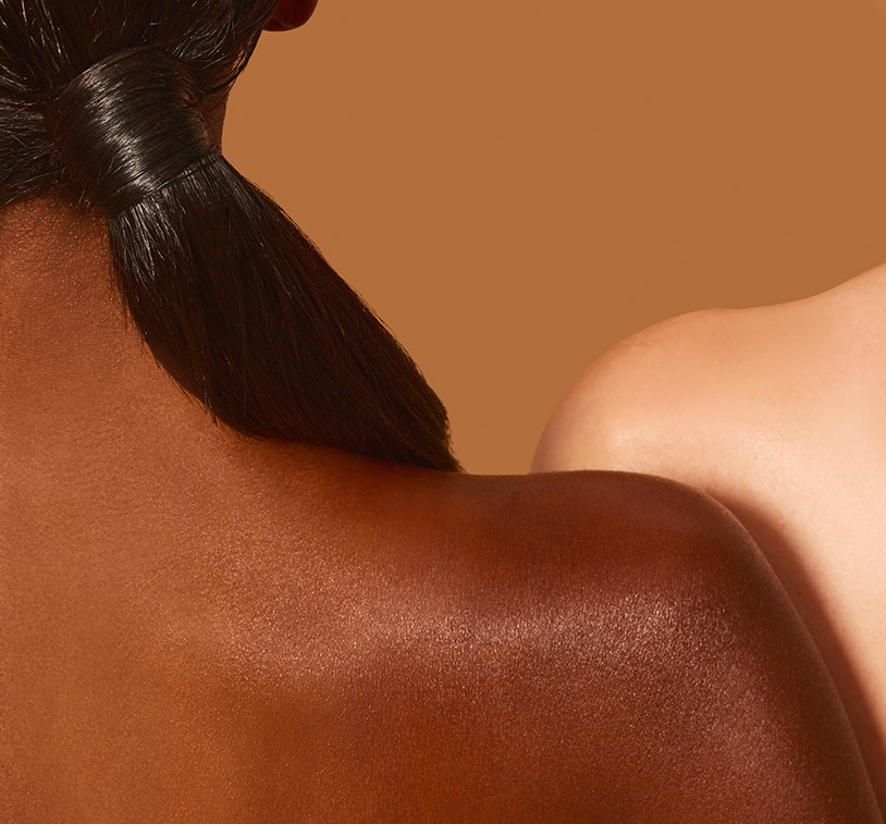 Closeup of an african-american & a caucassian women's shoulders. This picture is intended to show its results in different 
      types of skin.