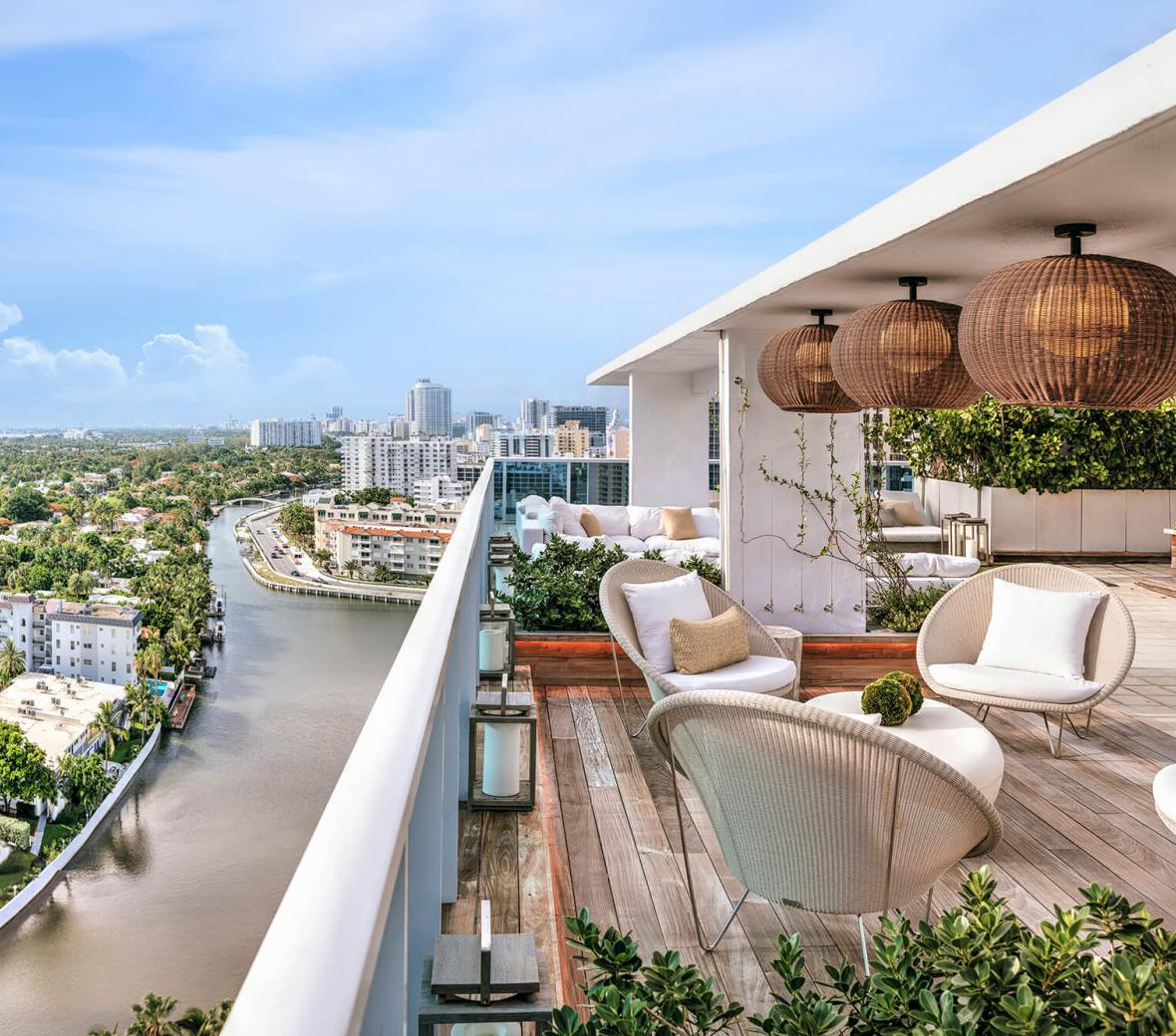 Terrace at a hotel with sofas and chairs overseeing the Miami landscape.