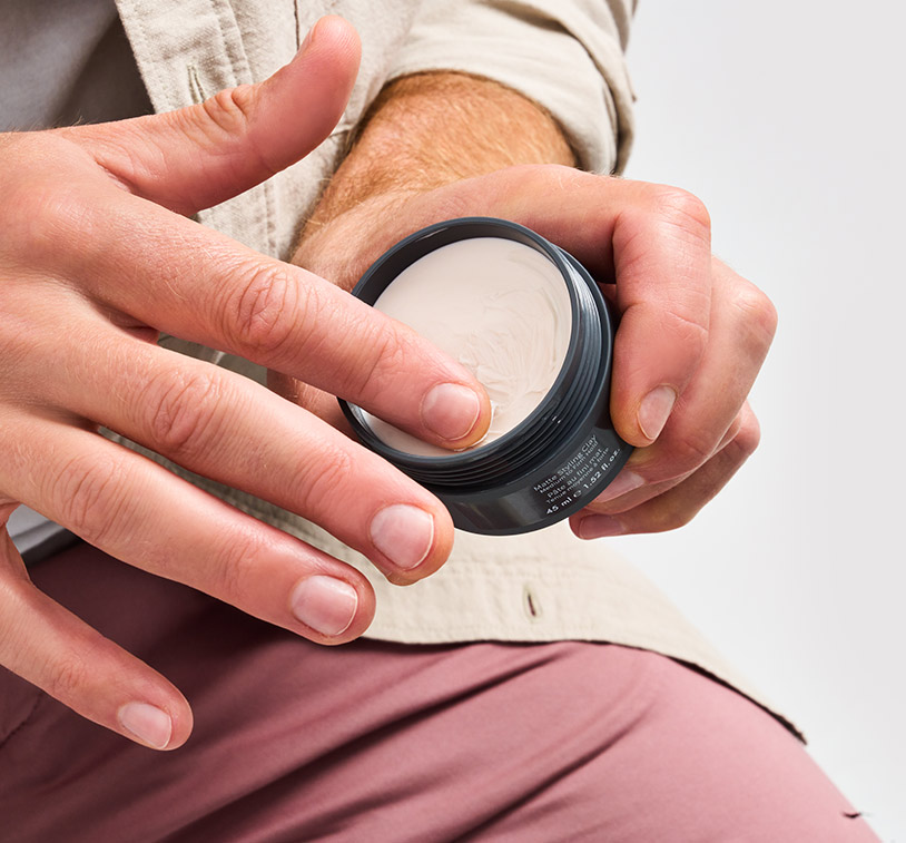 picture of a man working a small amount of product into his hands.