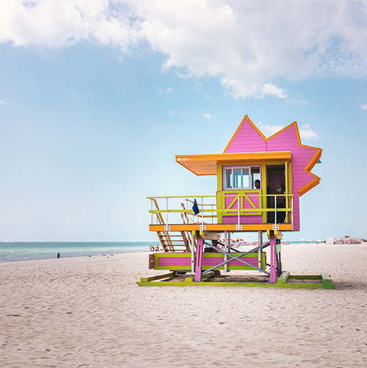 Pink, orange and green lifeguard kiosk at a beach in Miami. Photo Leah Kelley - Pexels