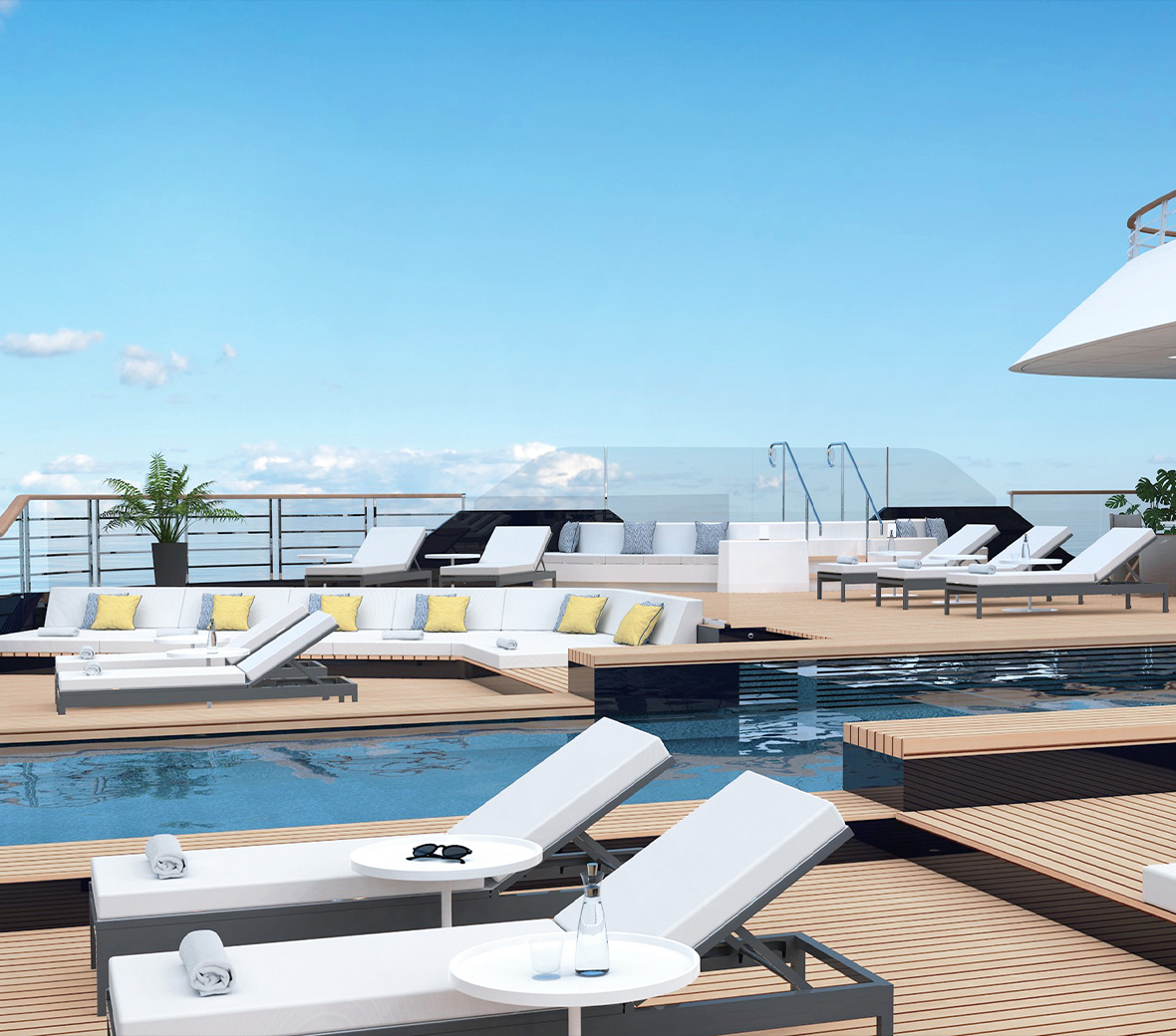 White lounge chairs on a wooden deck, around a pool.