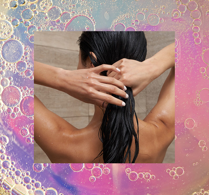 A female washing her hair in the shower, overlaying a photo of bubbles on an iridescent background.