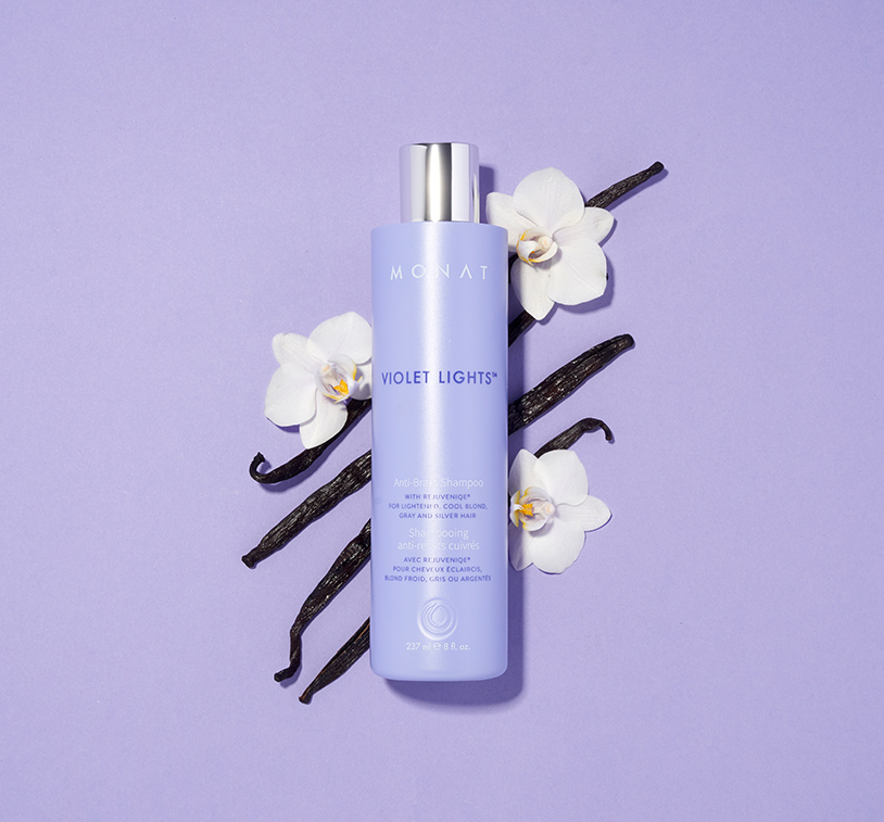 Violet Lights™ Anti-Brass Shampoo on a purple background with white orchids.