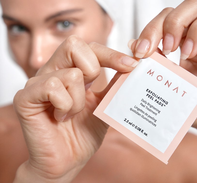 female holding monat exfoliating peel pads sachet.