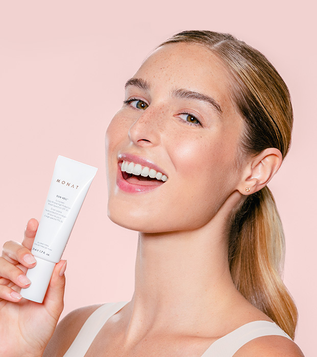 Model holding/using Sun Veil™ Daily Mineral Protection SPF 30