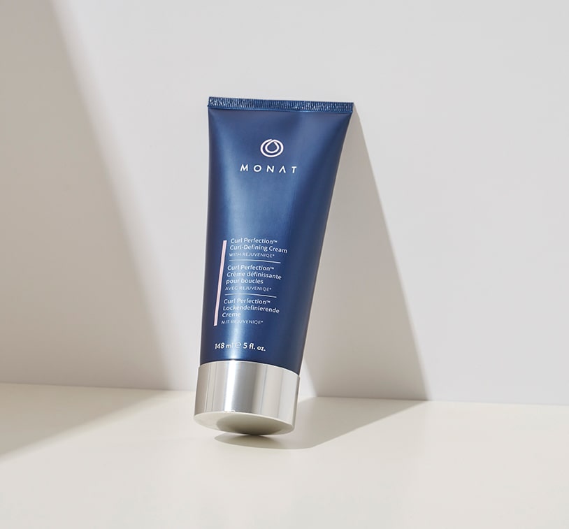 Tube of MONAT Curl Perfection™ Curl Defining Cream placed on a white background.