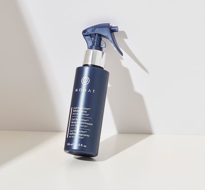 Bottle of MONAT Curl Perfection™ Refresh Spray placed on a white background.