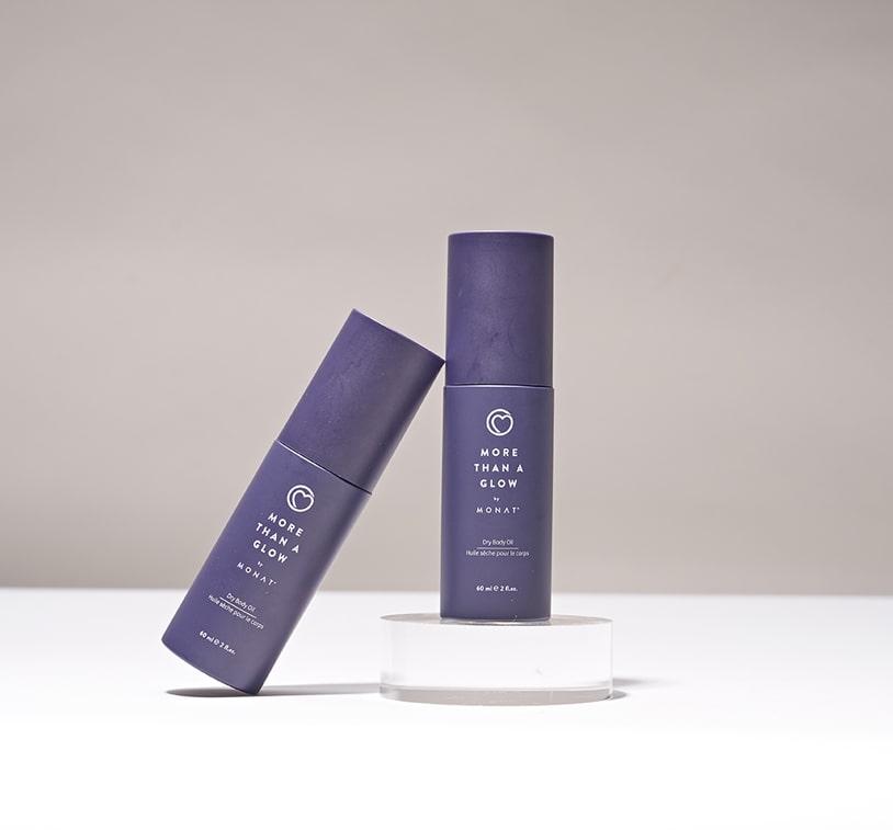 Image of two 'More Than a Glow by MONAT' product bottles, one standing upright and the other lying on its side, against a white background.