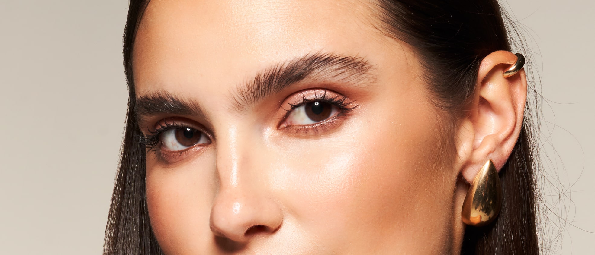 Close-up of a model's face with a subtle makeup look, highlighting the eyeshadow from the Glam Essentials Palette.