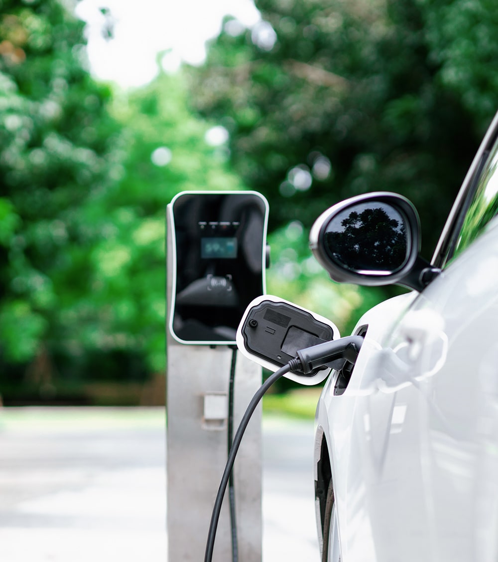 A white electric car that is charging. 