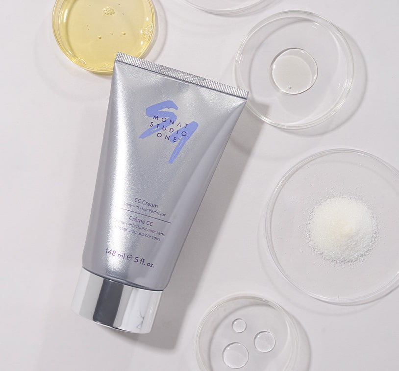 A bottle of MONAT STUDIO ONE™ CC Cream product displayed alongside small portions of its key ingredients, emphasizing the product's natural composition.