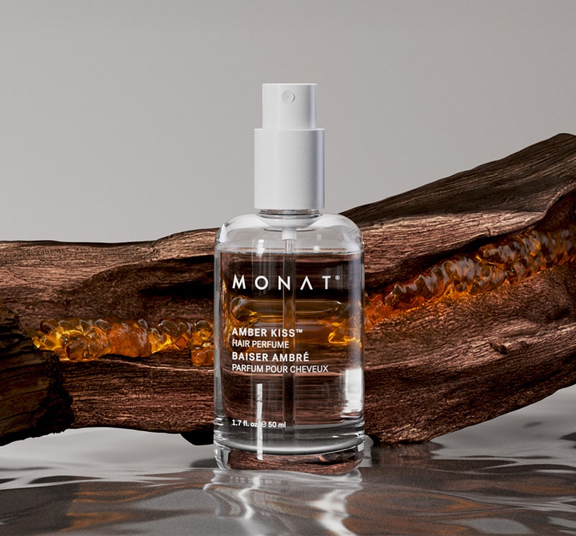 Amber Kiss Hair Perfume standing beside amber resin and wood