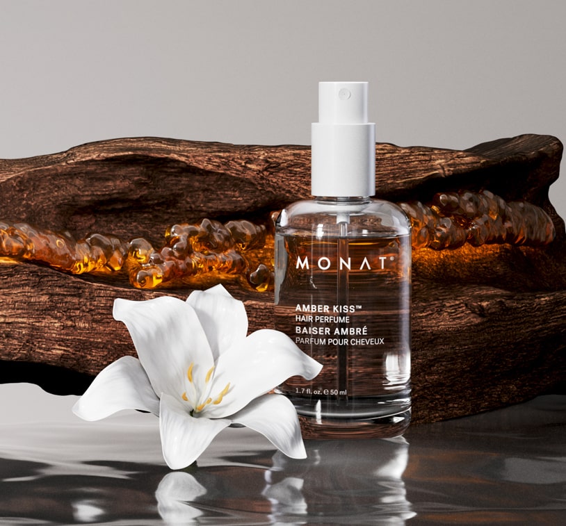 Amber Kiss Hair Perfume placed on wood with a white flower and amber resin accents