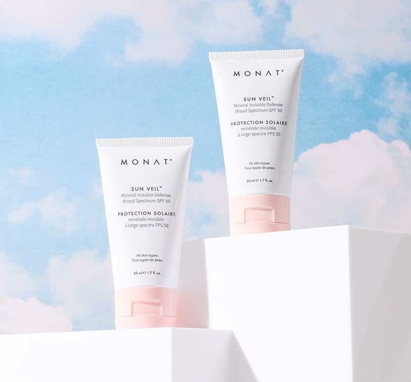 Two tubes of Sun Veil Mineral Invisible Defense-Broad Spectrum-SPF-50 displayed on blocks with a pastel sky background