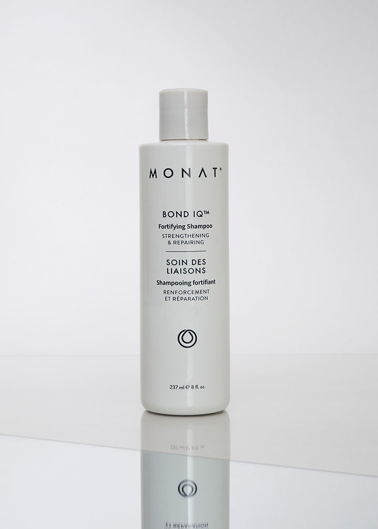 Tall white bottle of MONAT BOND IQ™ Fortifying Shampoo displayed upright