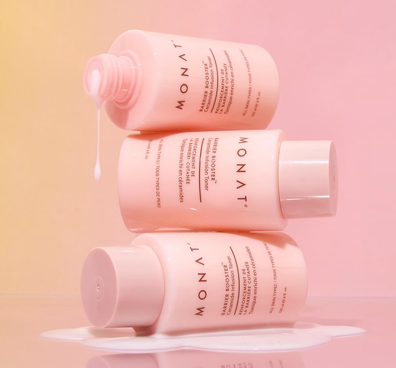 Three pink toner bottles stacked creatively against a light pink background