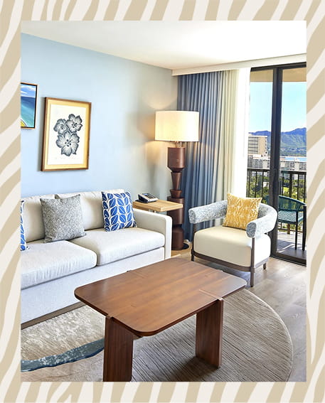 Bright, modern hotel room with ocean view balcony featuring white furnishings and natural light