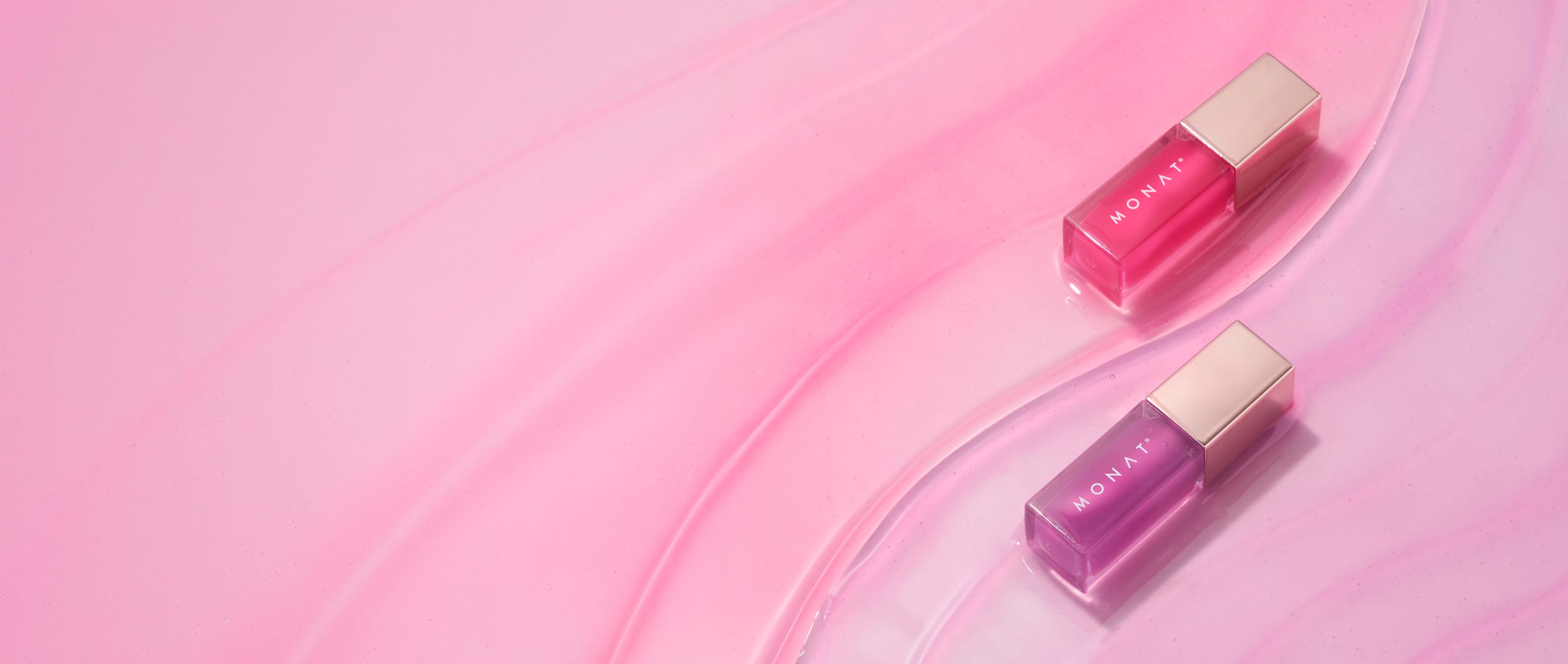 Two MONAT GlowTint™ Lip Oil bottles in Flirt (pink) and Dream (purple) on a glossy, marbled pink background.