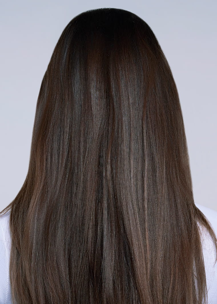 Close-up of long, smooth, straight brown hair showing a glossy finish