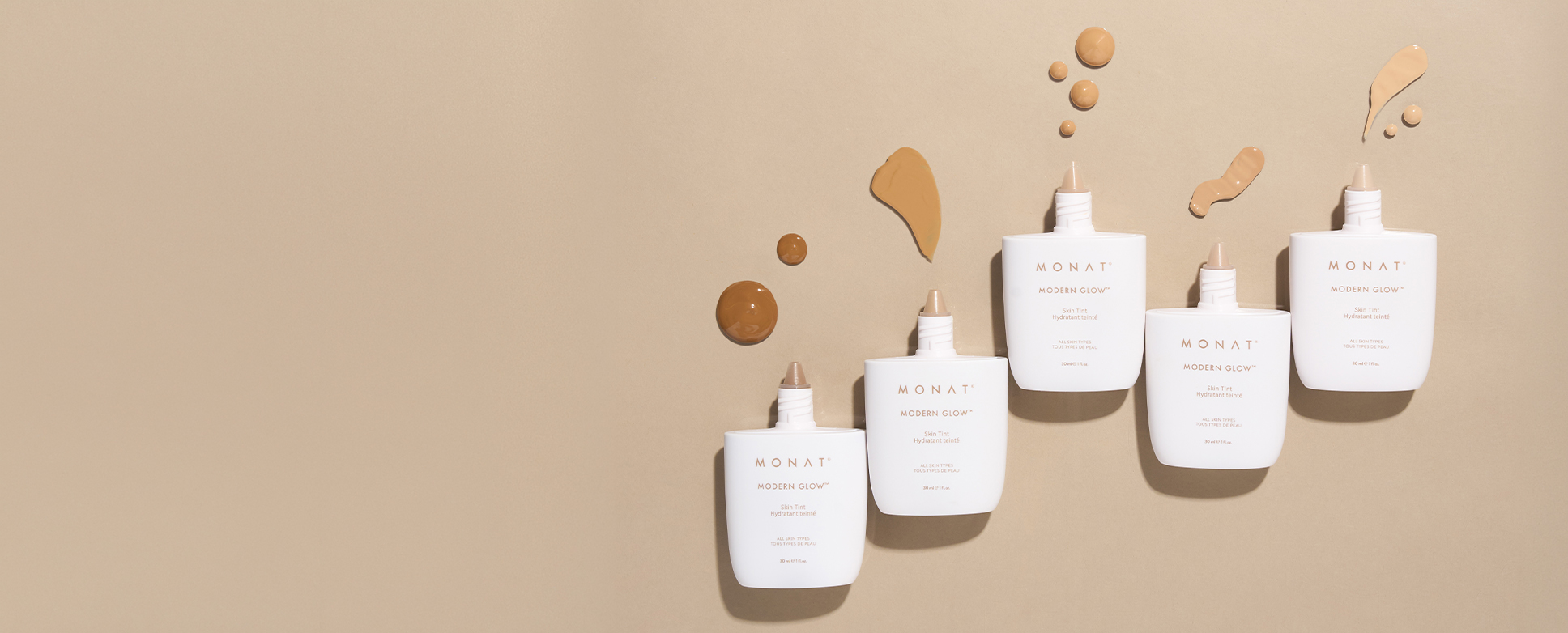 Five MONAT Modern Glow skin tint bottles arranged on a warm beige background with swatches of product above them.