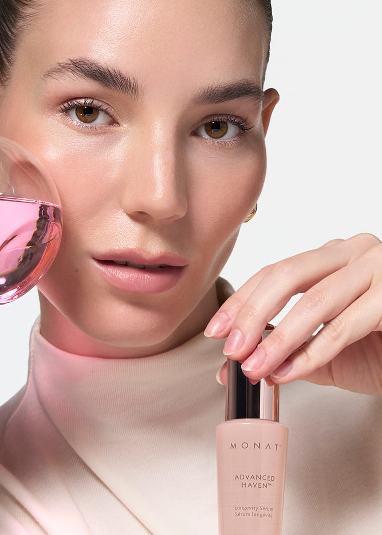 Woman applying MONAT ADVANCED HAVEN™ Longevity Serum to her cheek with a dropper