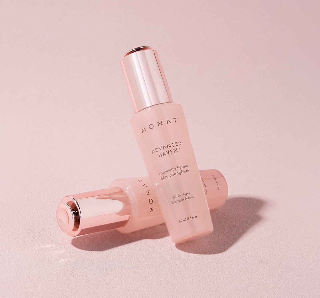 Two bottles of MONAT ADVANCED HAVEN™ Longevity Serum on a pink background