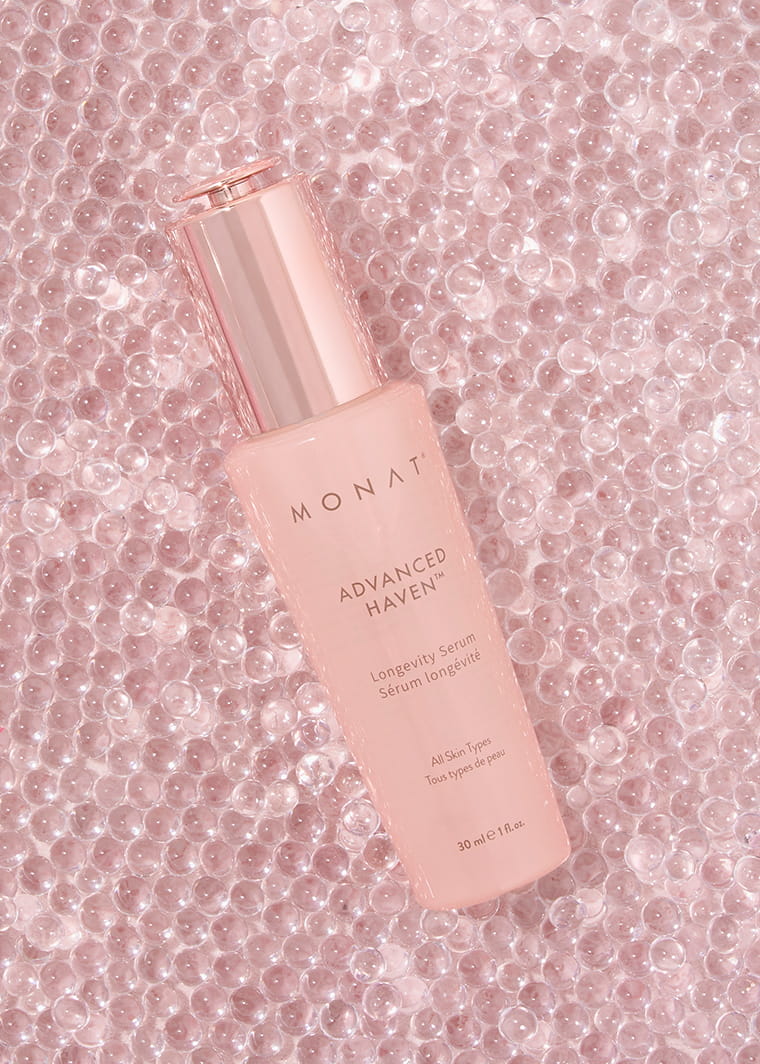 Close-up of MONAT ADVANCED HAVEN™ Longevity Serum bottle on a soft pink background